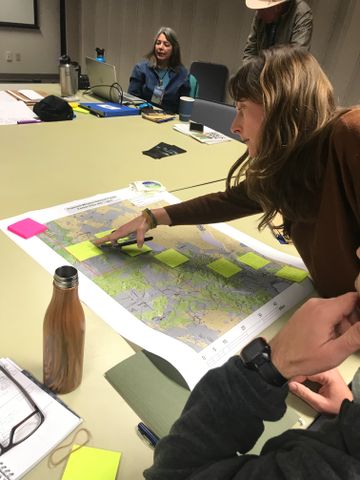 A woman points to a map on a table at aOutback Dark Sky Network meeting in Lakeview March 2020.